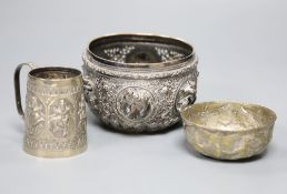 A 19th century Indian white metal embossed sugar bowl, a christening mug and a small brass bowl. (