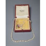 A single strand graduated cultured pearl necklace with yellow metal and gem set clasp (ex. ring