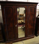 A Victorian mahogany three door wardrobe, with a central mirrored door, width 190cm depth 60cm