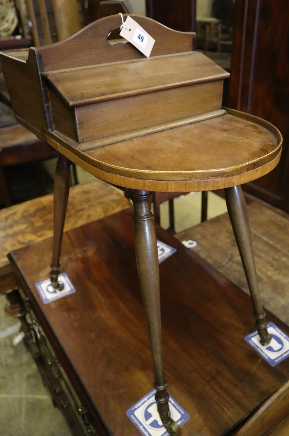 A Victorian mahogany sewing table on slender splayed baluster legs with brass caps and castors,