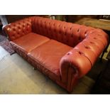 A Victorian style buttoned pale red leather Chesterfield settee, width 220cm depth 100cm height