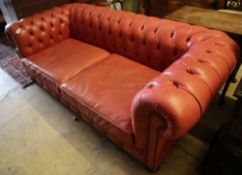 A Victorian style buttoned pale red leather Chesterfield settee, width 220cm depth 100cm height