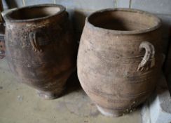 A pair of three-handled terracotta oil jars, each with ribbed sides and narrow foot, height 100cm (