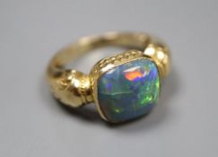 A yellow metal and opal set dress ring, size I, gross 7.4 grams.CONDITION: There are numerous