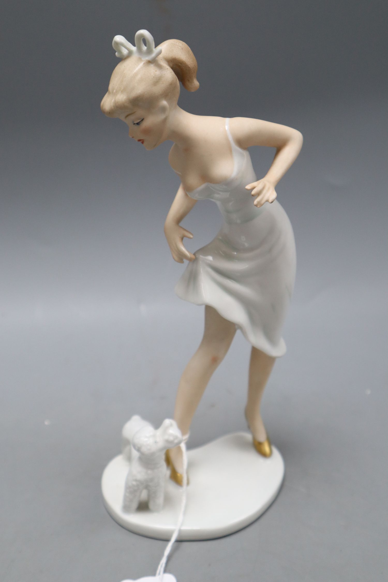 A Goebel figure of a woman and a poodle, height 23cmCONDITION: Some minor flaws in the manufacture