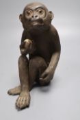 A Japanese stoneware figure of a monkey holding a peach, height 17cm