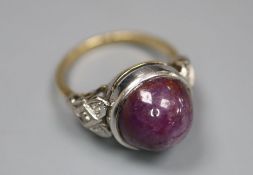 An 18ct and plat, cabochon purple star sapphire set ring, with diamond set shoulders, size N,