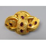 A Victorian yellow metal and seven stone garnet set scroll brooch, 47mm, gross 13.1 grams.CONDITION: