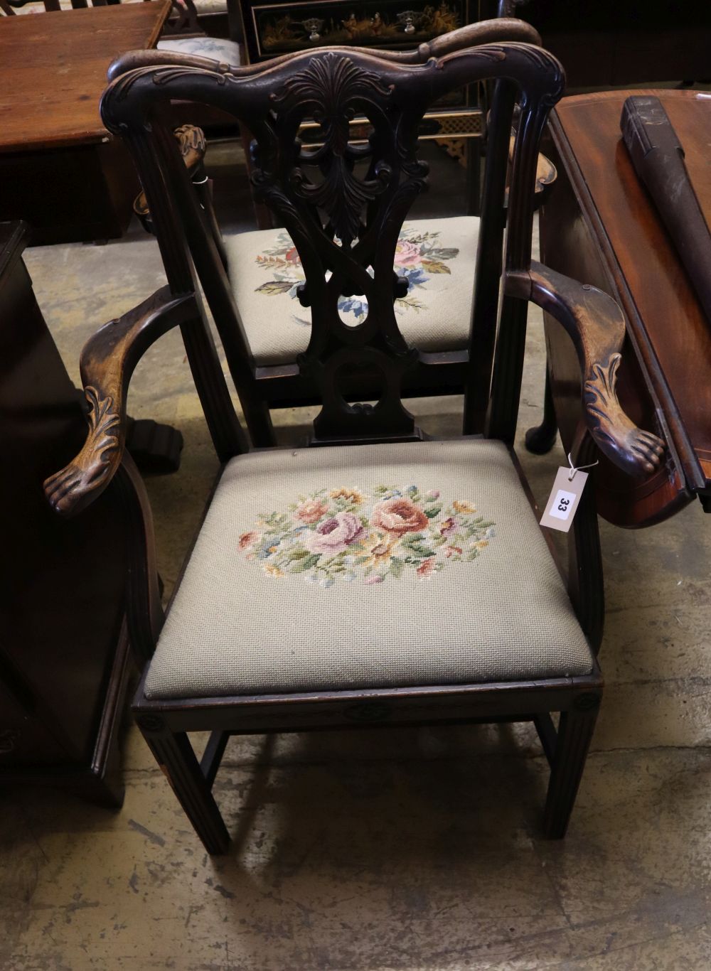 A pair of 19th century mahogany elbow chairs, scroll and leaf-carved and with lion's paw armrests