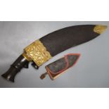 A kukri with skinning knives, leather sheath with elaborate embossed gilt metal mounts, blade 36cm