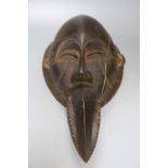 A Dan carved wood 'beak' mask, Ivory Coast (split)