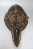 A Dan carved wood 'beak' mask, Ivory Coast (split)