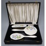 A three piece silver plated translucent enamelled dressing table set, cased