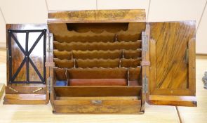 A Victorian figured walnut table stationery cabinet having sloping front with double doors opening