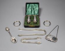 Small silver including a pair of Georgian sugar tongs, cased pepperettes, two napkin rings, spoon,