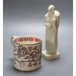 A Wedgwood commemorative Coronation mug designed by Richard Guyatt and an earthenware figure of a