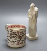 A Wedgwood commemorative Coronation mug designed by Richard Guyatt and an earthenware figure of a