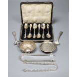 A cased set of six silver teaspoons spoons, two pairs of tongs, paten dish and three other items.