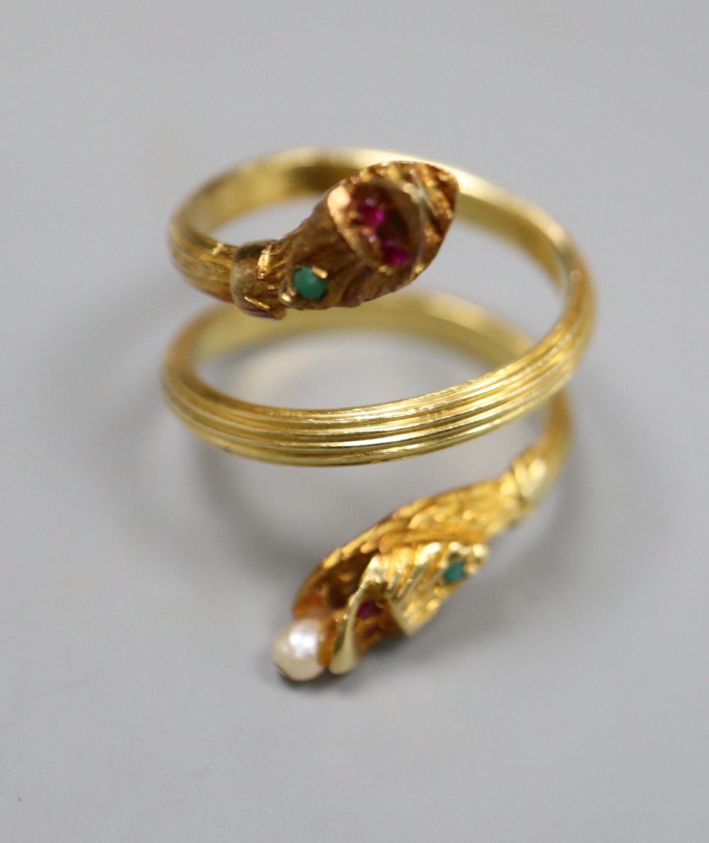 A Georgian style reeded yellow metal and gem set twin headed serpent ring, seed pear later added,