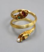 A Georgian style reeded yellow metal and gem set twin headed serpent ring, seed pear later added,