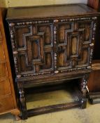 A 17th century and later oak cabinet of drawers enclosed by a pair of panelled doors, with