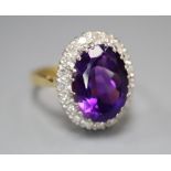 A 1970's 18ct gold, amethyst and diamond set oval cluster dress ring, size Q, gross 7.8 grams.