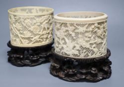 A pair of early 20th century Chinese ivory pots, with carved wood stands, overall height 16cm