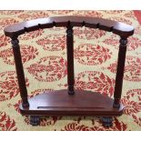 A mahogany sword stand, bow shape with reeded columns, claw feet, 92cm