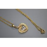 A modern Chopard style 18k and 'floating' diamond set heart shaped pendant, on a 750 chain,