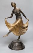 A patinated metal model of a 1930's dancer, on stepped circular base, 48cm