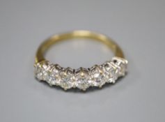 A modern 18ct gold and graduated seven stone diamond half hoop ring, size P, gross 3.6 grams.