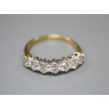 A modern 18ct gold and graduated seven stone diamond half hoop ring, size P, gross 3.6 grams.