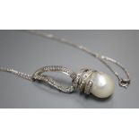 A modern 14k white metal, baroque pearl and diamond set drop pendant, on 750 white metal chain,