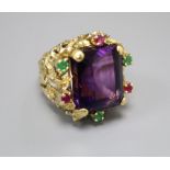 A yellow metal, amethyst, emerald and ruby cluster set naturalistic dress ring, size M, gross 20.9