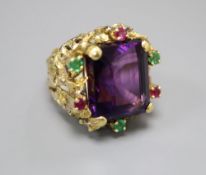 A yellow metal, amethyst, emerald and ruby cluster set naturalistic dress ring, size M, gross 20.9