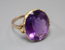 A 19th century gold and amethyst dress ring (tests as 9ct), with collet setting and carved