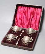 A cased set of four late Victorian silver salts, of two handled trophy cup form and matching spoons,