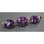 A modern white metal, three stone oval cut amethyst and diamond chip set bar brooch, 55mm, gross