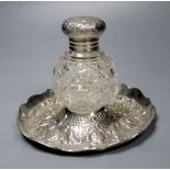 A late Victorian repousse silver mounted glass inkwell, on a repousse silver stand, London, 1891,