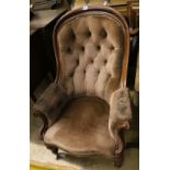 A Victorian mahogany-framed armchair covered in deep-buttoned dralon