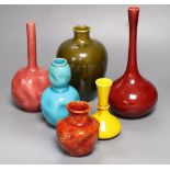 A collection of Burmantofts faience pottery vases, comprising a dark pink ground bottle-shaped