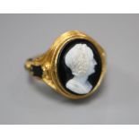 A Victorian 18ct gold cameo ring, of carved scrolled design with black enamelled decoration and