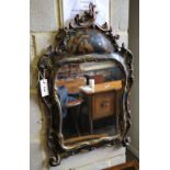 An 18th century style chinoiserie wall mirror, the cartouche shaped plated within cushioned
