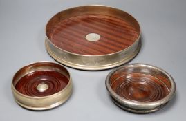 A large modern silver mounted table coaster, 25.7cm and two other modern wine coasters, one silver.