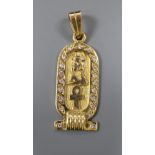 An Egyptian yellow metal and diamond set hieroglyphics pendant, 27mm, gross 4.3 grams.