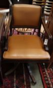 A Reprodux mahogany and tan leather swivel desk chair