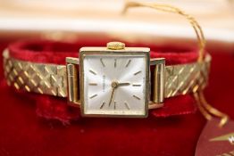 A lady's 9ct gold Longines manual wind square dial wrist watch, on 9ct bracelet, with Longines