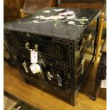 A Chinese black-lacquered brass-mounted small two-door cabinet, the door panels decorated with