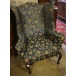 A George I style mahogany framed wing armchairCONDITION: Fading and wear to the upholstery,