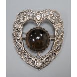 A large late Victorian pierced silver and cabochon quartz? set shield shaped brooch, 81mm.